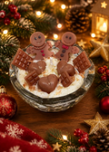 Handgefertigte Kerze Weihnachtsnascherei in einer Glasschale mit zwei Lebkuchenfiguren, Schokoladenherzen und Schokoladenstückchen aus Wachs, umgeben von Weihnachtsdekoration I Manufaktur Wohlleben